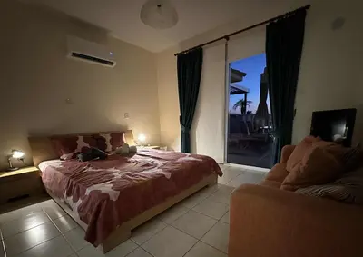 a bedroom with a large bed and a balcony at Nissi Golden Sands Lome in Ayia Napa