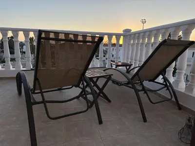two chairs sitting on a balcony with a railing at Nissi Golden Sands Lome in Ayia Napa