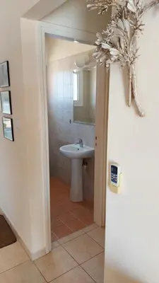 a white bathroom with a sink and a mirror at Nissi Golden Sands Lome in Ayia Napa
