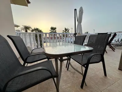 a table and chairs on a balcony with an umbrella at Nissi Golden Sands Lome in Ayia Napa