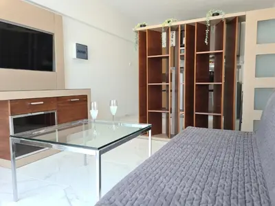a living room with a glass coffee table and a tv at Fotoxenia Luxury Apts in Paralimni
