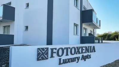 a building with a sign that reads fotologia luxury apartments at Fotoxenia Luxury Apts in Paralimni
