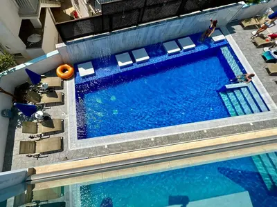 an overhead view of a swimming pool with chairs and water at Sunny Blue Hotel in Ayia Napa
