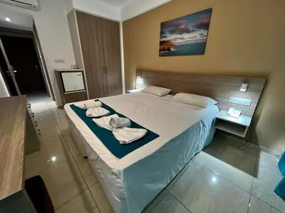 a bedroom with a large bed with towels on it at Sunny Blue Hotel in Ayia Napa