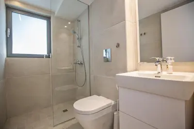 a bathroom with a toilet and a sink and a shower at The White H Villa, Protaras, Fresh and Peaceful in Paralimni