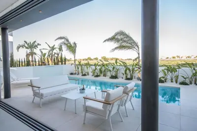 a patio with white furniture and a swimming pool at The White H Villa, Protaras, Fresh and Peaceful in Paralimni