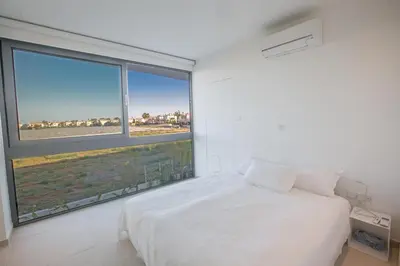 a bedroom with a white bed and a large window at The White H Villa, Protaras, Fresh and Peaceful in Paralimni
