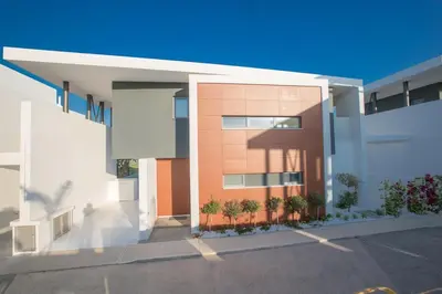 a white and orange building with a parking lot at The White H Villa, Protaras, Fresh and Peaceful in Paralimni