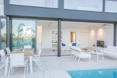 a living room with a table and chairs and a pool at The White H Villa, Protaras, Fresh and Peaceful in Paralimni