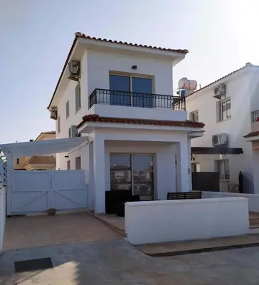 a large white house with a blue gate at KapparisVilla in Paralimni