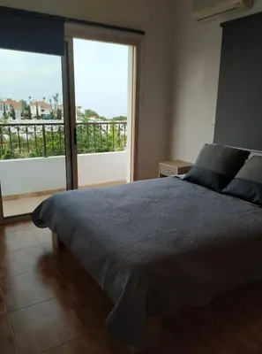 a bedroom with a bed and a large window at KapparisVilla in Paralimni