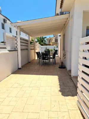 a patio with a table and chairs under a pergola at KapparisVilla in Paralimni