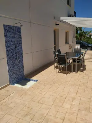 a patio with a table and chairs and a tile floor at KapparisVilla in Paralimni