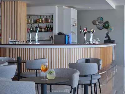 a restaurant with tables and chairs and a bar at Atlantica Sea Breeze, Adults Only in Protaras