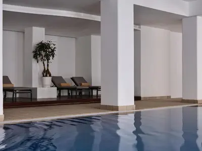a pool in a building with chairs and a plant at Atlantica Sea Breeze, Adults Only in Protaras