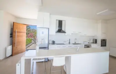 a white kitchen with a large white counter top at Leda Villa in Protaras