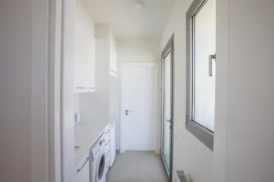 a hallway with white walls and a mirror at Leda Villa in Protaras