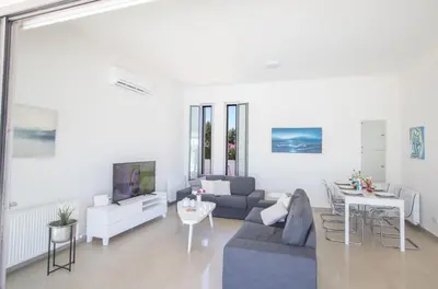 a living room with a couch and a tv at Leda Villa in Protaras