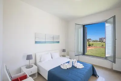 a bedroom with a bed and a large window at Leda Villa in Protaras