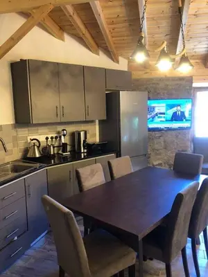 a kitchen with a wooden table and chairs and a kitchen with a kitchen gmaxwell gmaxwell at To Spiti tou Faliari in Platanistasa