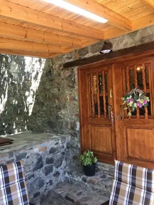 a porch of a stone building with a wooden door at To Spiti tou Faliari in Platanistasa