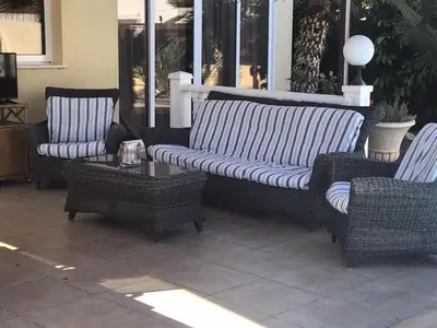 a couch and two chairs and a table on a patio at Carolyn Villa is a Luxury 4-Bedroom Villa with Private Pool in Ayia Napa in Ayia Napa