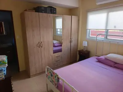 a bedroom with a bed and a cabinet with purple sheets at Carolyn Villa is a Luxury 4-Bedroom Villa with Private Pool in Ayia Napa in Ayia Napa