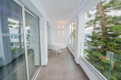 a balcony with large windows and a table and chairs at Anthea Hotel Apartments in Ayia Napa