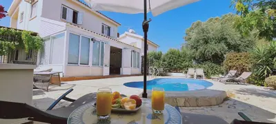 a table with a bowl of fruit next to a pool at STAY Swallow's Nest Villa in Ayia Napa