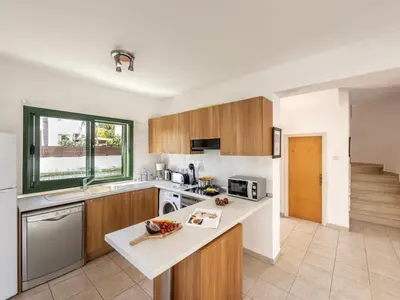 a kitchen with wooden cabinets and a counter top at Villa Eftihia in Protaras