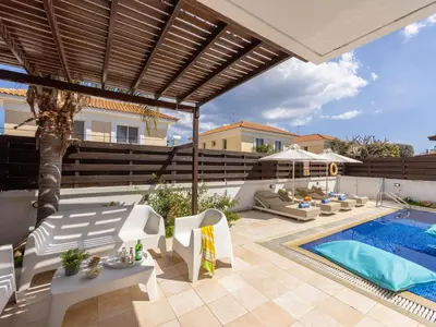 a patio with a swimming pool and a villa at Villa Eftihia in Protaras