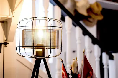 a lamp on a tripod with flags in a room at Casa BOHO in Alaminos