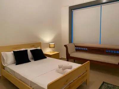 a bedroom with a bed and a couch and a window at Central Suites Down Town Nicosia in Nicosia
