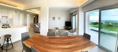a kitchen and living room with a wooden table at Emerald Suites in Protaras