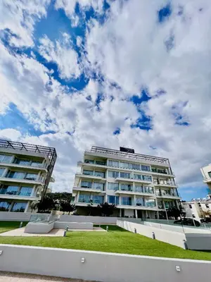 a large apartment building with a cloudy sky in the background at Emerald Suites in Protaras