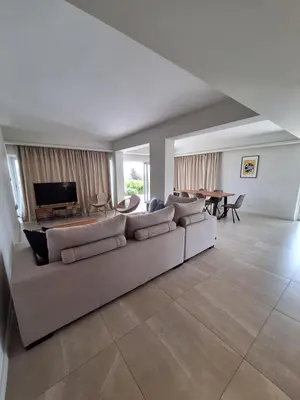 a living room with a couch and a television at Emerald Suites in Protaras