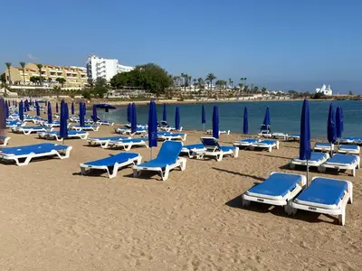 a group of lounge chairs and umbrellas on a beach at KSQUARED in Protaras