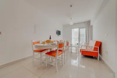 a white dining room with a table and chairs at Christos Napa Self Serviced Apartments in Ayia Napa