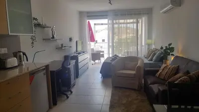 a kitchen and a living room with a couch and a table at Pyla Gardens A202 Studio in Pyla