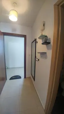 a hallway with a door to a room with a window at Pyla Gardens A202 Studio in Pyla