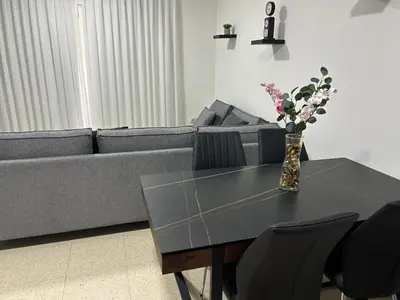 a living room with a couch and a table with flowers at Mersey Faros Complex in Pervolia