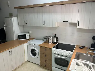 a kitchen with a washing machine and a sink at Mersey Faros Complex in Pervolia