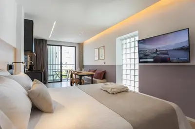a bedroom with a large bed with a television on the wall at Alinea Urban Saripolou Square in Limassol