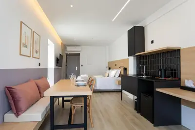 a kitchen and living room with a bed and a table at Alinea Urban Saripolou Square in Limassol
