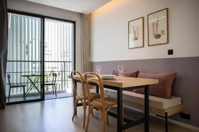 a dining room with a table and chairs and a balcony at Alinea Urban Saripolou Square in Limassol