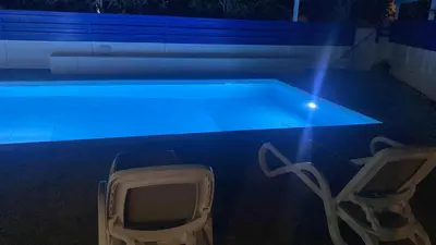 a swimming pool with two chairs and a tv in it at Olive Tree Villa - Protaras in Protaras