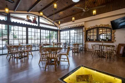a restaurant with tables and chairs in a room with windows at Anais Bay Hotel in Protaras