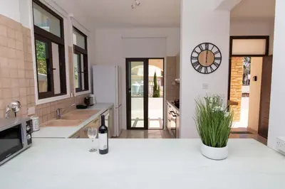 a kitchen with a bottle of wine and a clock on the wall at Mylos 9 in Protaras