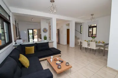a living room with a black couch and a table at Mylos 9 in Protaras
