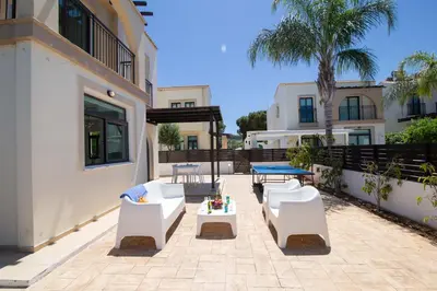a patio with white furniture and a table and chairs at Mylos 9 in Protaras